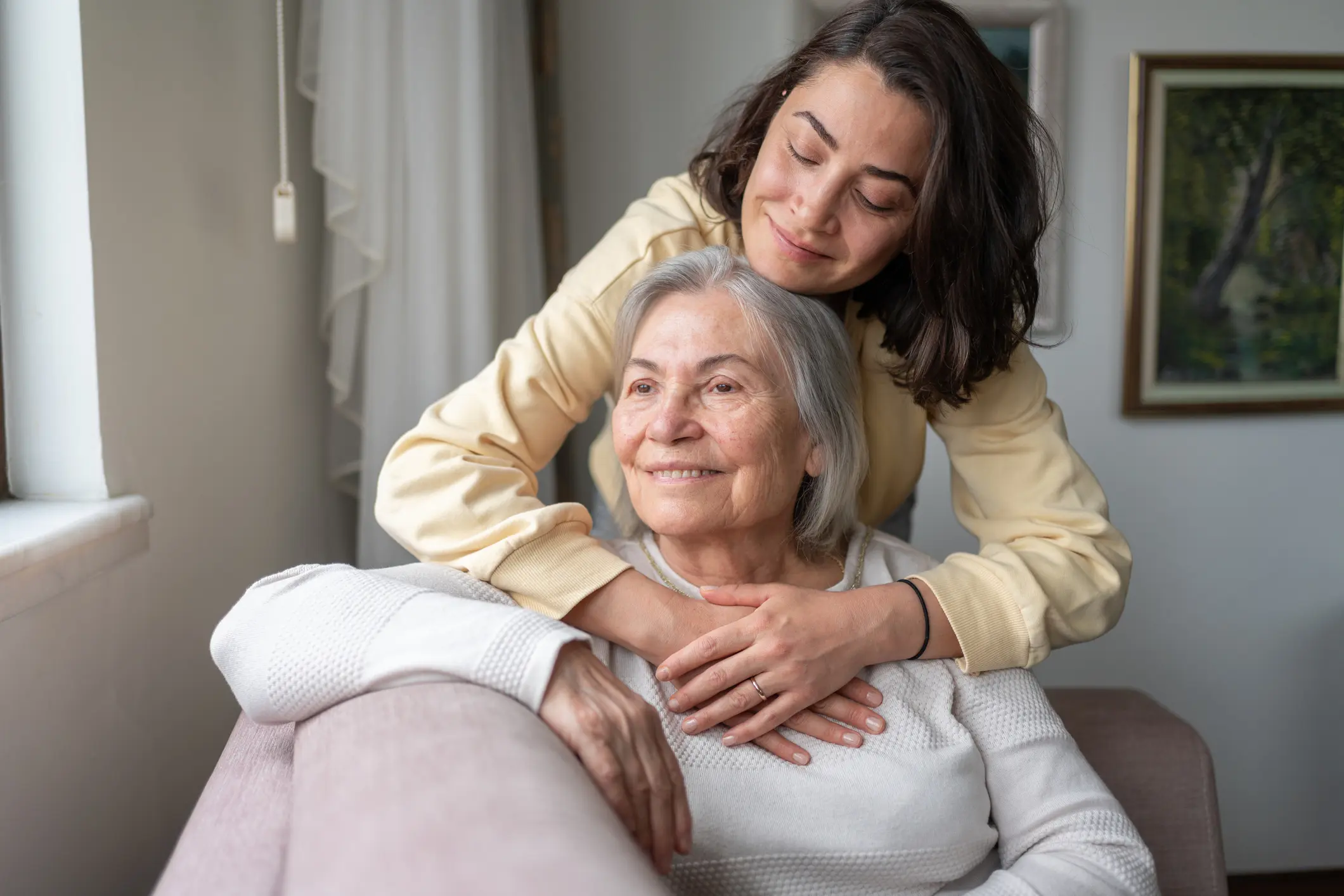 Daughter embraces elderly mother lovingly